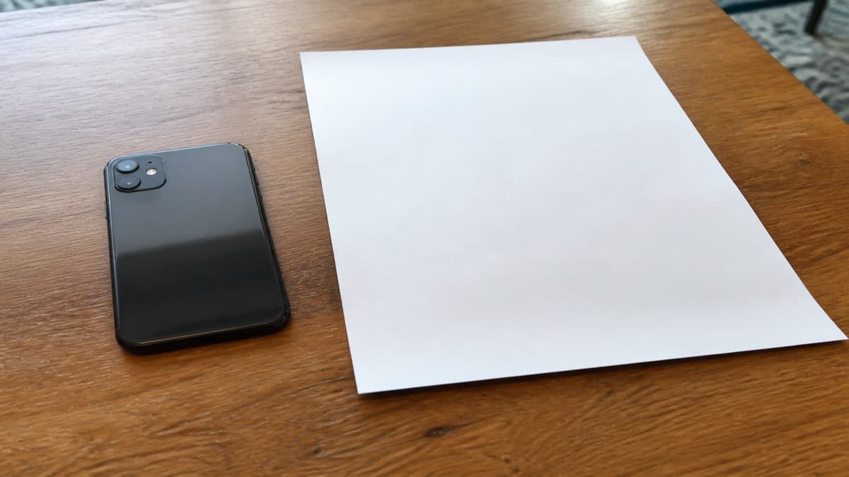 Laptop showing a LinkedIn profile next to a printed resume with matching job dates highlighted
