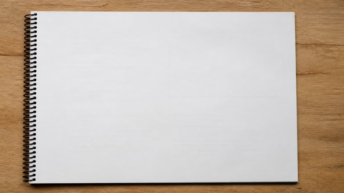 Printed one-page and two-page resumes side by side on a desk next to a laptop and a red pen